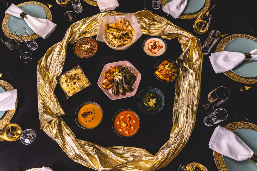 Gala table with gold runner and Indian dishes